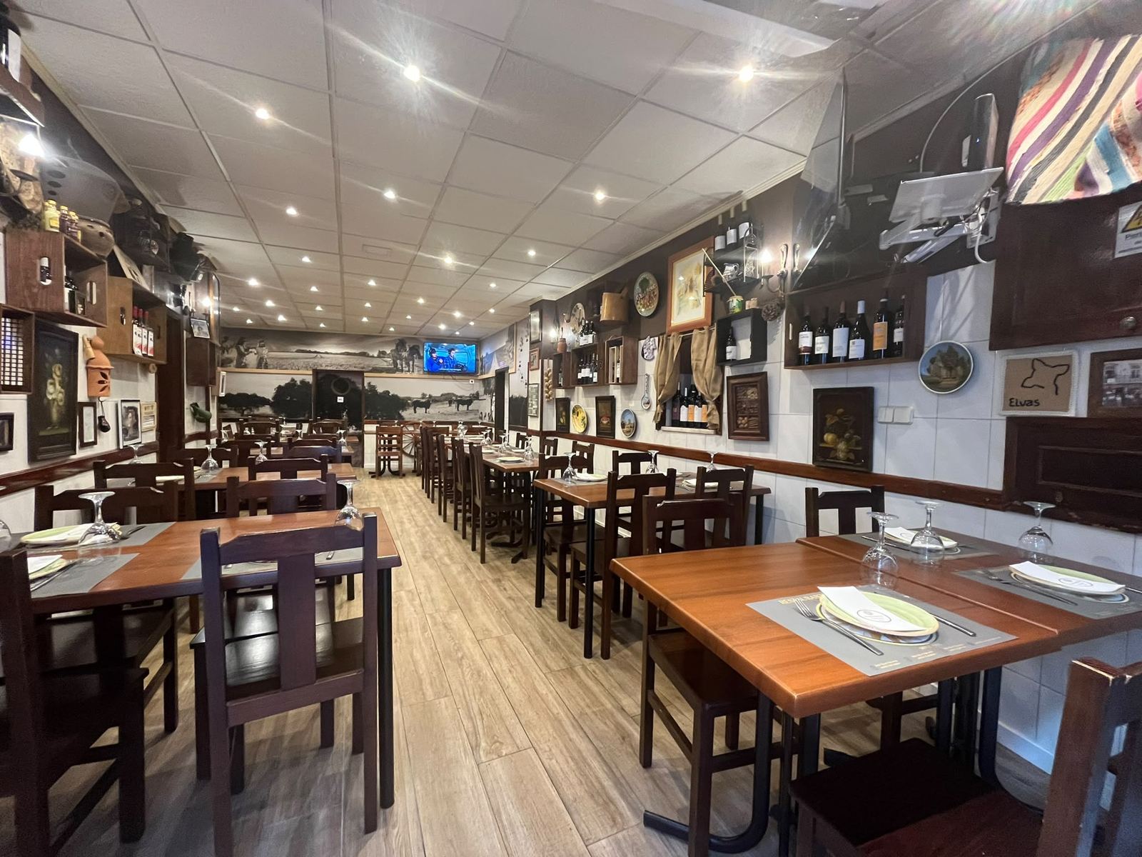 Sala principal do Restaurante Girassol, com mesas postas e parede decorada com fotografias do Alentejo